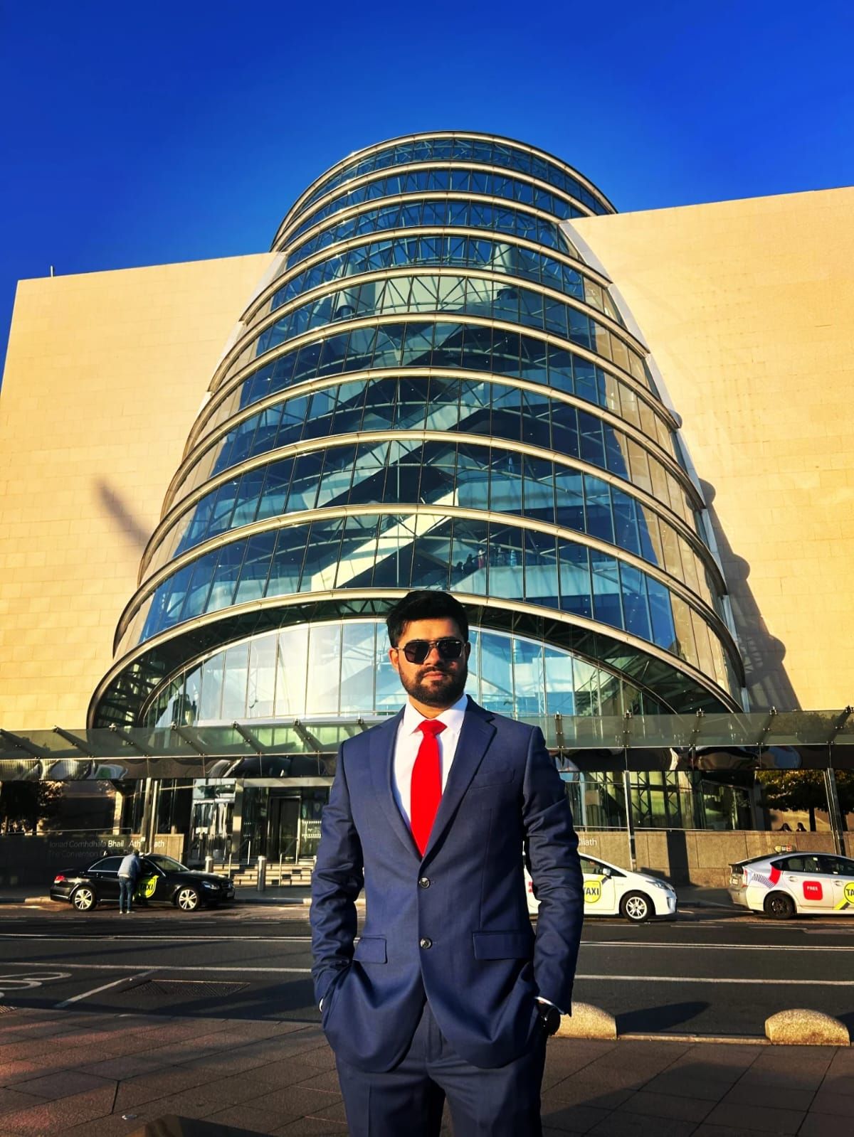 Malav Naik in a suit outside a curved glass building – Precision vs Recall in Content Moderation: The Trade-Off Every Integrity Team Faces