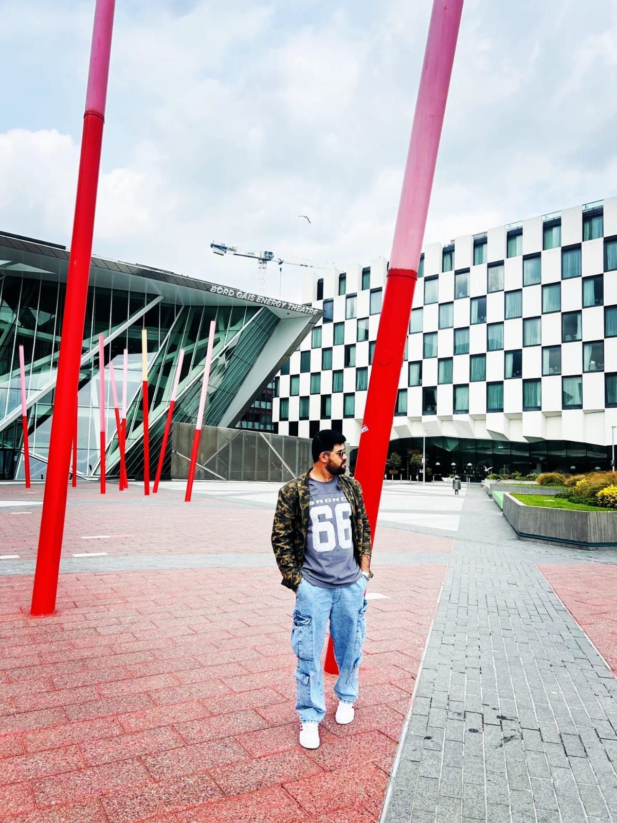 Malav Naik in a square with red poles and modern buildings – What 1.8 Million Comments Taught Me About Fair Content Moderation
